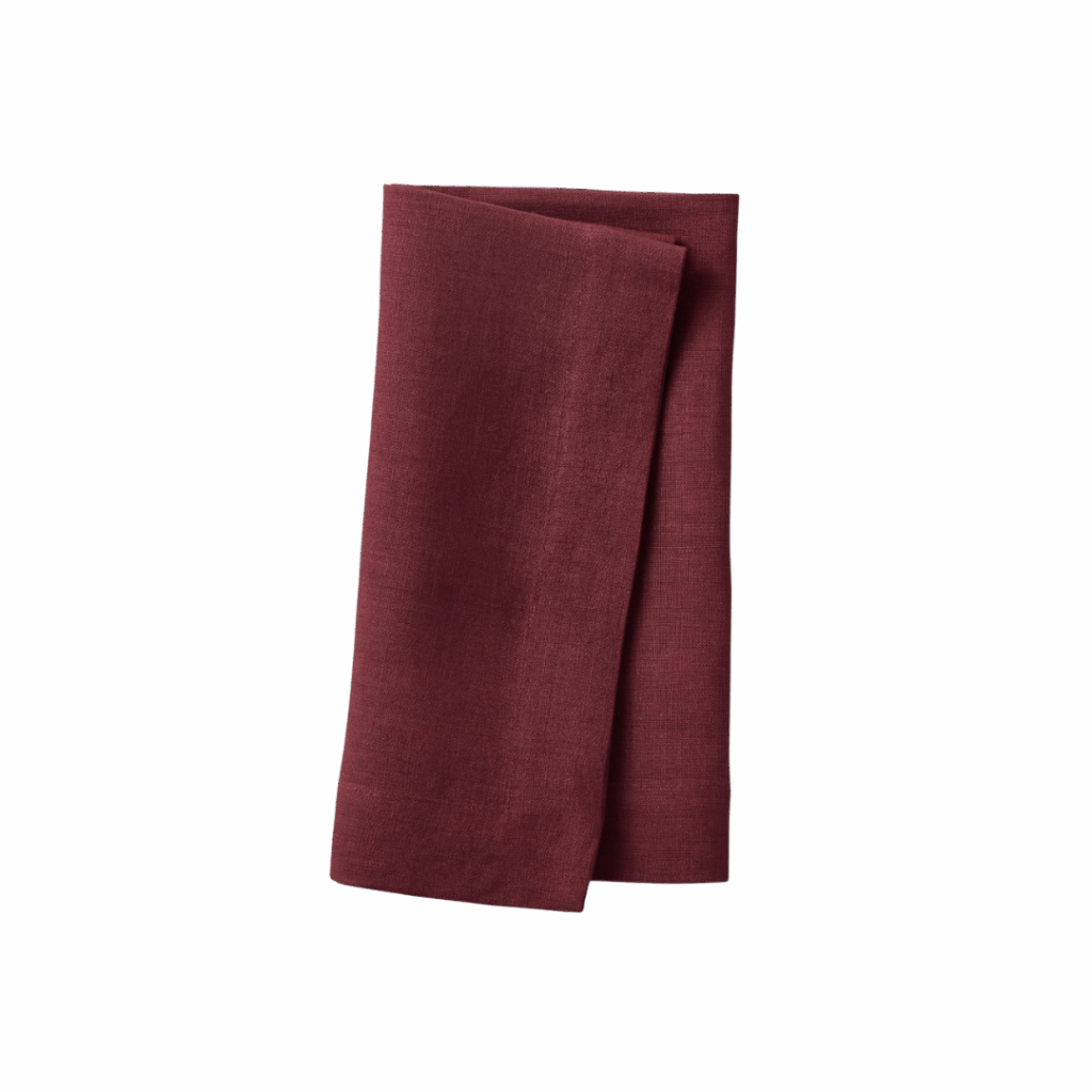 A folded dark red cloth napkin, ideal for hosting, is displayed on a plain white background.